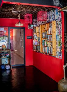 珍南海滩House of Lion Hostel的一间设有红色墙壁的客房,配有书籍