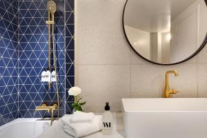 巴黎Artemisia Montmartre的带浴缸、水槽和镜子的浴室