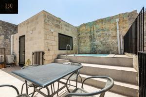 姆迪纳Historical Mdina Gem, Lux HOME with Rooftop Pool by 360 Estates的一个带桌椅的庭院和一个游泳池