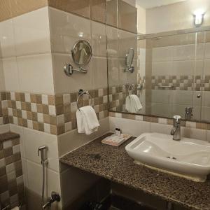 王舍城Aarunya Hotel And Resort的一间带水槽和镜子的浴室