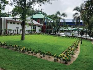 王舍城Aarunya Hotel And Resort的一座公园,在一座建筑前有鲜花