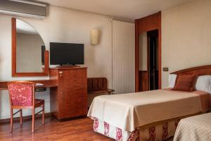 安道尔城ALEGRIA President的酒店客房配有一张床和一张书桌及一台电视