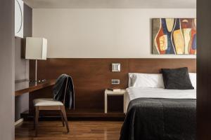 安道尔城ALEGRIA President的配有一张床和一把椅子的酒店客房