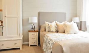 纽基Newperran Holiday Park的一间卧室配有带枕头的床铺和床头柜