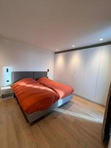 洛克里斯蒂ApartHotel Dénia的一间卧室配有一张带橙色床单和白色橱柜的床。