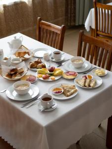 博罗沃耶Hotel Alma-Ata的一张带食物盘和咖啡杯的白色桌子