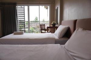 董里长普那卡林公寓的酒店客房设有两张床和窗户。