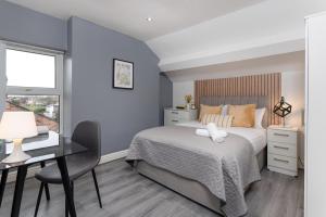 Walton on the HillHost Liverpool - Ideal for extended stays的一间卧室配有一张床、一张书桌和一个窗户。