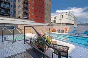 坎卢普斯希尔顿逸林酒店 - 坎卢普斯 的一座大楼的顶部,设有一座带热水浴缸的游泳池
