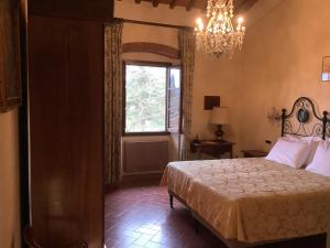 雷杰洛瑞伽奇别墅酒店的一间卧室设有一张床、一个窗户和一个吊灯。
