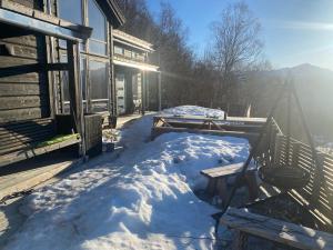 SaudaModerne hytte i Svandalen, Sauda - nær skisenter og natur的雪覆盖的房屋门廊,阳光灿烂