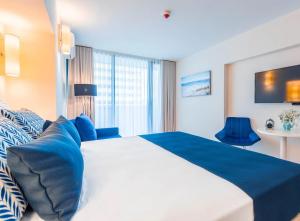 巴统Orbi City Sea View 24/7的酒店客房配有一张带蓝色枕头的大床
