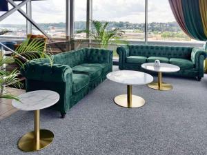 考纳斯IBIS Styles Kaunas Centre的客厅配有绿色沙发和2张桌子