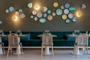 马里尼亚讷Hilton Garden Inn Marseille Provence Airport的一间带两张桌子和一张绿色沙发的餐厅