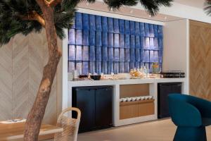 马里尼亚讷Hilton Garden Inn Marseille Provence Airport的一间客厅,配有棕榈树和一张桌子