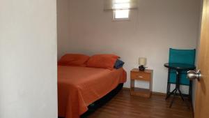 拉塞雷纳BELLAS Y COMODAS HABITACIONES EN LA SERENA的一间卧室配有一张床和一张蓝色椅子