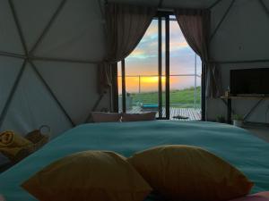 伊斯特雷托达卡耶塔Soul Glamping的一间卧室配有一张床,享有日落美景