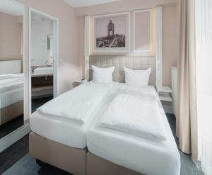 诺德奈Villa Ney的白色的卧室配有一张白色的大床和镜子