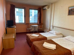 索非亚Hotel Brod - Free Parking的酒店客房带两张床和一张桌子以及椅子。