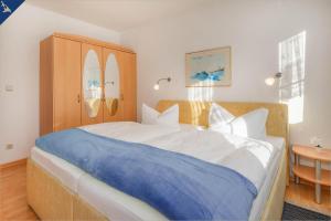 赛巴特班森Apartment Seemöwe的一间卧室配有一张带蓝色毯子的大床
