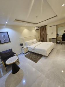 伊凯贾LUXOL HOMES&SUITES的卧室配有一张白色的大床和一张沙发。