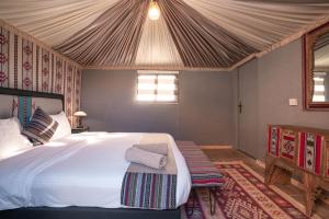 瓦迪拉姆迎宾沙漠营地酒店的帐篷内一间卧室,配有一张大床