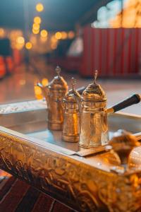 瓦迪拉姆迎宾沙漠营地酒店的桌上的盘子,上面有四个茶壶