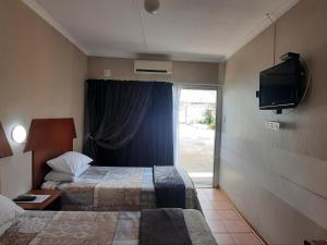 库鲁曼Kalahari Kaja的酒店客房设有两张床和电视。
