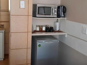 库鲁曼Kalahari Kaja的带微波炉和小冰箱的小厨房