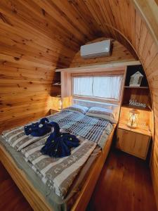 帕科坦MALI NORDSEE Mobilehomes & Glamping的木制客房内的一间卧室,配有一张床