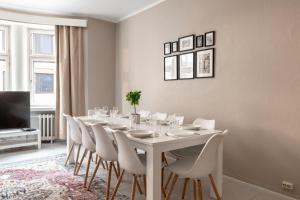 赫尔辛基2ndhomes Bright & Spacious, 5 Bedroom Apartment in the Center的白色的用餐室配有白色的桌椅