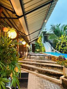 尼甘布最佳居住地住宿加早餐旅馆的一个带游泳池和带楼梯的庭院的度假酒店