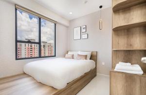 胡志明市Otis Soho Saigon Balcony Apartment的一间卧室设有一张大床和一个大窗户