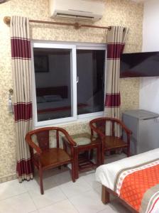 顺化玉平酒店的一间卧室设有窗户、两把椅子和一张床