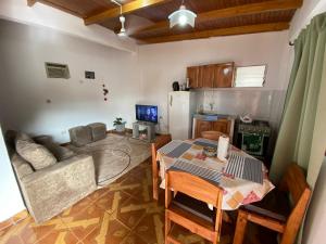 伊瓜苏港Leosan departamento的厨房以及带桌子和沙发的客厅。