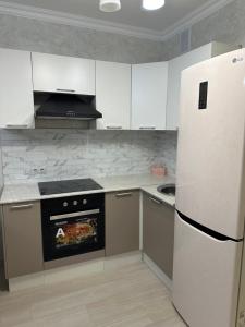 Prigorodnyyоднокомнатная квартира的厨房配有白色家电和白色冰箱