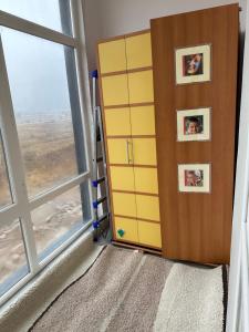 Prigorodnyyоднокомнатная квартира的一间设有黄色橱柜和窗户的房间