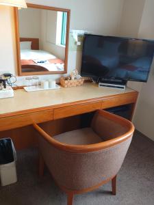 青森Aomori Green Park Hotel Annex的一张桌子、一台电视、镜子和椅子