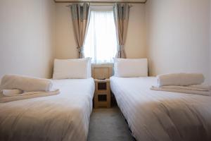 Saint HelensSt Helens Coastal Resort的小型客房 - 带2张床和窗户