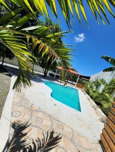 拉维加Pa' la Finca的棕榈树屋旁的游泳池