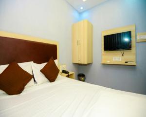 苏拉特Hotel sunrise cave vesu的卧室配有一张床,墙上配有电视。