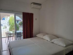 帕拉马里博玛雅公寓的一间带白色床的卧室和一个阳台