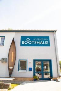 贝斯科Boootshaus - Am Spreeufer的书店,在建筑物的一侧有蓝色标志