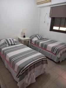 科连特斯Céntrico departamento en Corrientes的两张睡床彼此相邻,位于一个房间里