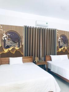 宁平TAMCOC VUTHANH FRIENDLY Hotel的一间卧室设有两张床和一面带镜子的墙壁