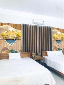宁平TAMCOC VUTHANH FRIENDLY Hotel的一间卧室配有两张床和窗帘