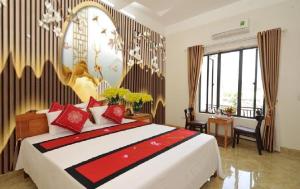 宁平TAMCOC VUTHANH FRIENDLY Hotel的一间卧室配有一张带红色枕头的大床