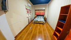 伊瓜苏港Lumay的一间卧室配有一张床,铺有木地板