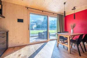 施坦斯The Swiss Bijou / Alpine Retreat的一间带木桌和大窗户的用餐室