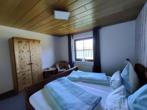 HerscheidKomfort Ferienwohnung的一间卧室配有一张带蓝色床单的床和一扇窗户。